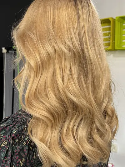 Długie blond włosy ułożone w miękkie fale