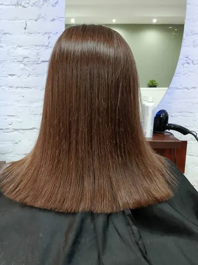 Ciemny blond w połysku, proste włosy ścięte w równą linię